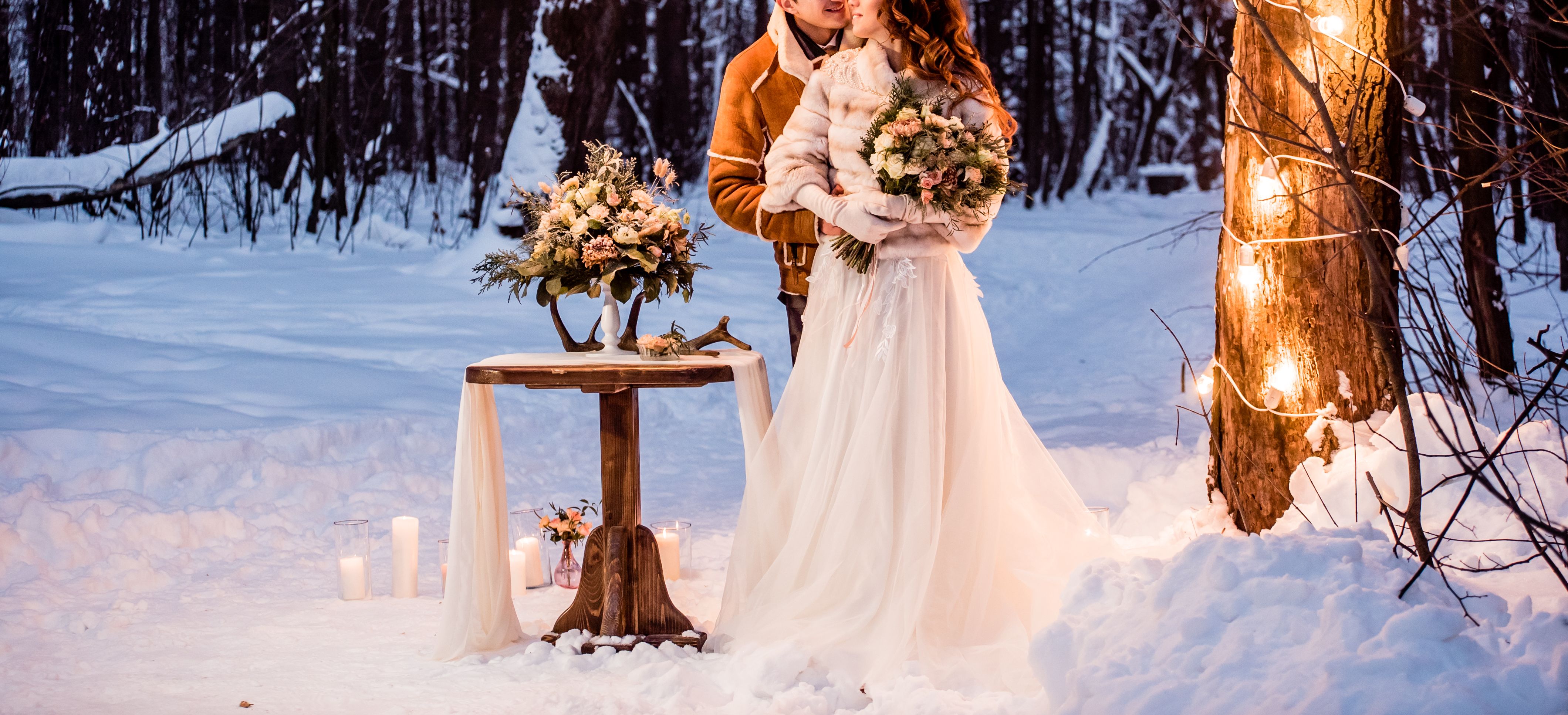 Novomanzelsky par ve snehu s dekoraci kolem sebe